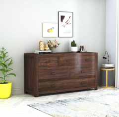 Sheesham wood chest of six drawers in walnut finish styled in a room